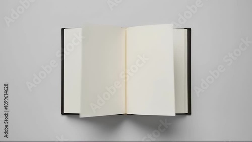 Top view of an open book with blank white pages flipping automatically. Empty notebook paper turning with copy space for text. Education and storytelling mockup background