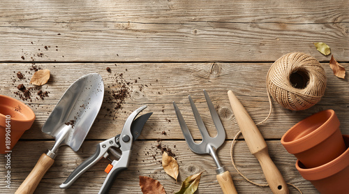 Gardening tools and terracotta pots on a rustic wooden surface. Flat lay of trowel pruners and twine