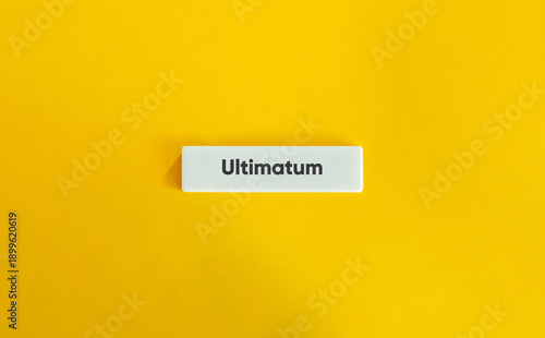 Conceptual Minimalist Image of Ultimatum Word on White Block over Vibrant Yellow Background representing Final Demand Business Negotiation and Urgency
