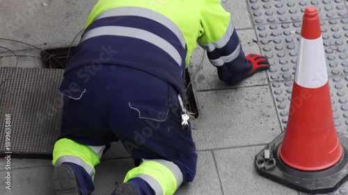electrician worker install traffic light or optical fiber cables for internet and telephone underground lines in city street , horizontal full hd video footage 