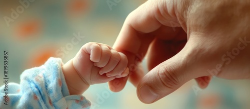 Baby's hand clasped in an adult's hand