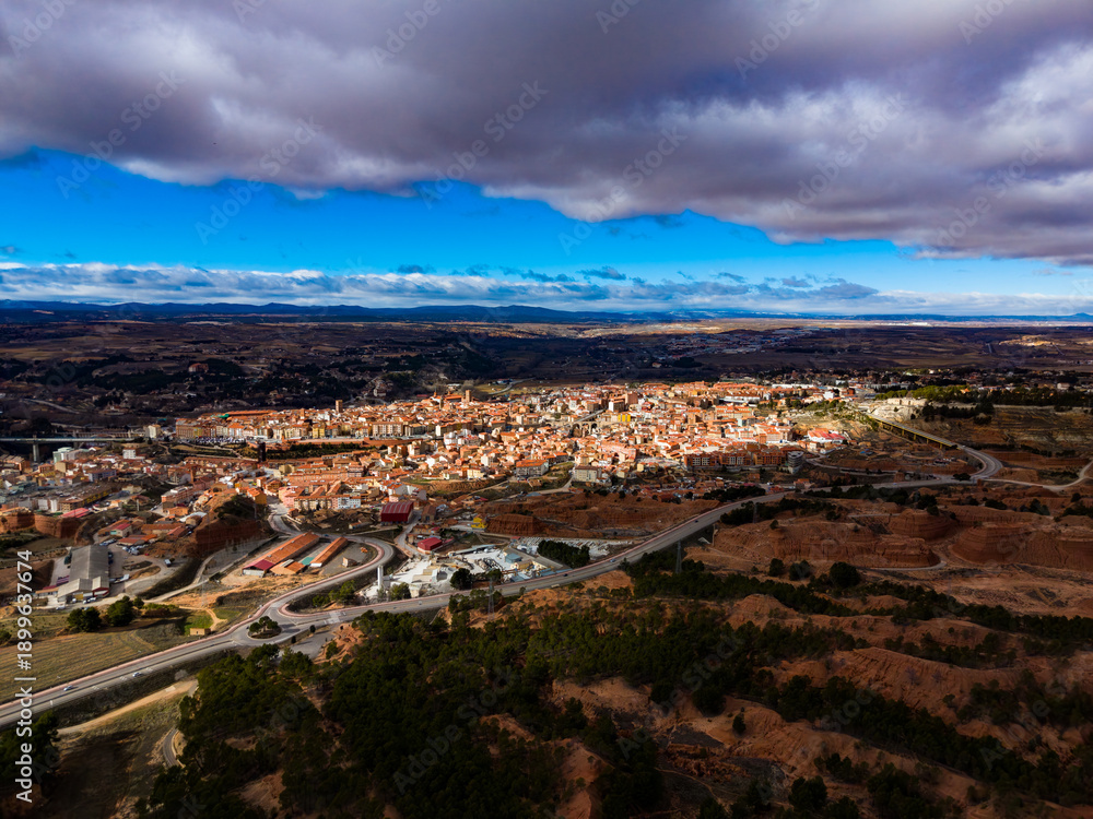 Obraz premium View of Teruel from a high point showing the city layout and surrounding landscape during daytime with clouds in the sky