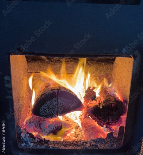 Foto Burning firewood inside a wood stove, glowing embers and bright flames creating