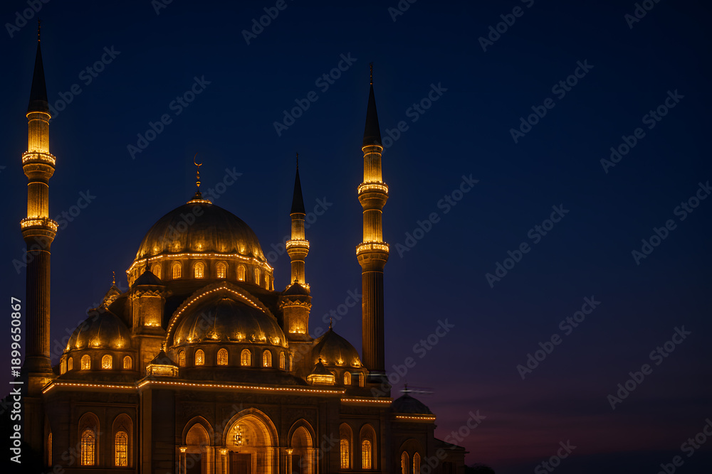 Naklejka premium A large mosque with illuminated domes and minarets at dusk
