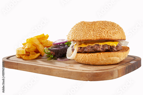 Hamburger with potatoes and vegetables on a wooden board