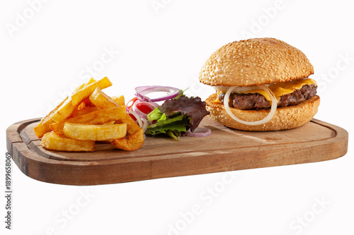 Hamburger with potatoes and vegetables on a wooden board