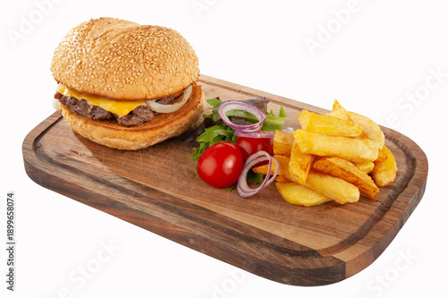 Hamburger with potatoes and vegetables on a wooden board