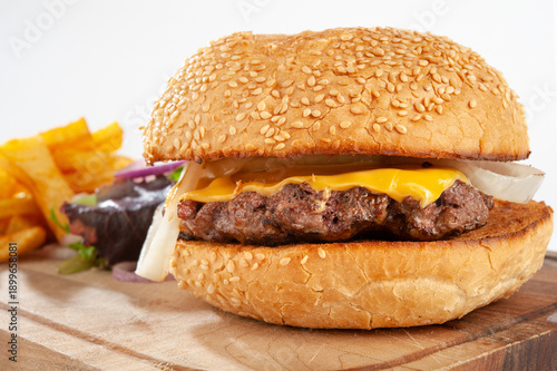 Hamburger with potatoes and vegetables on a wooden board