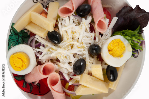 Salad with ham, tomatoes, eggs, olives, yellow cheese and onion