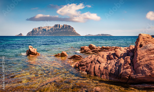 Astonishing summer view of Tavolara island from Spiaggia del dottore beach. Impressive morning scene of Sardinia island, Italy, Europe. Vacation concept background.