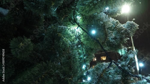 The Christmas tree shines with bulbs and garlands. Christmas tree with decorations, Christmas balls. Town Square on a festive night. Illumination in the city. Winter mood