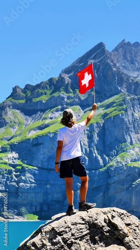 teenager holding swiss flag, lake and alps mountain in Switzerland
