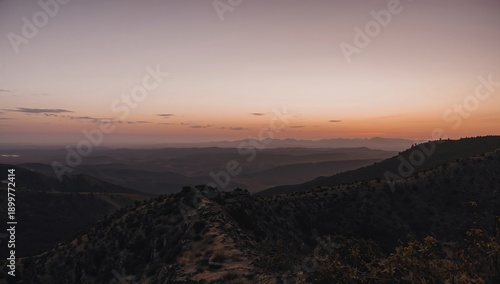 Sunrise Over Rolling Hills and Valleys in a Mountainous Region During Early M...