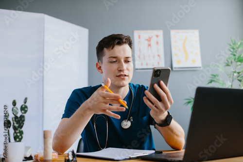 фотографія Young doctor providing online medical consultation using smartphone