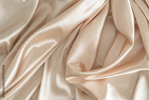 Beautiful smooth elegant wavy beige / light brown satin silk luxury cloth fabric texture, abstract background design. Copy space.