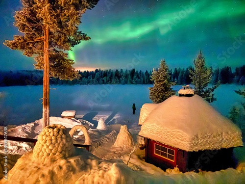 Cabin in the woods close to Ivalo, Lapland, Finland during Polar Night, North to the Arctic Circle during the natural phenomenon of Northern Lights in Winter