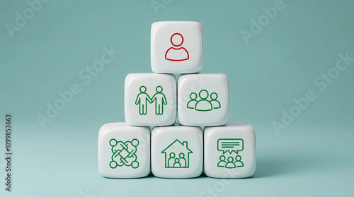 Pyramid of white dice with icons representing teamwork, family, community, leadership, and business concepts on a light blue background