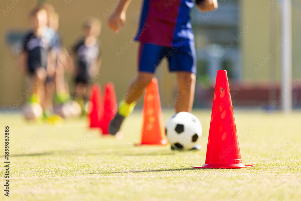 Obraz premium Kids Soccer Dribbling Drill with Cones; Youth Football Training Focused on Ball Control