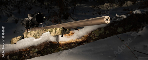 Φωτογραφία Close-up of a bolt action rifle in a snowy treeline