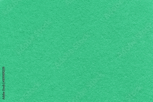 Emerald green textured paper background with subtle grain surface and soft structure, macro