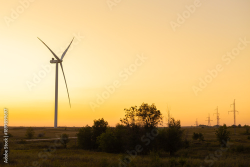 Renewable energy wind turbines in rural area at sunset, large modern propellers generating electricity from wind,