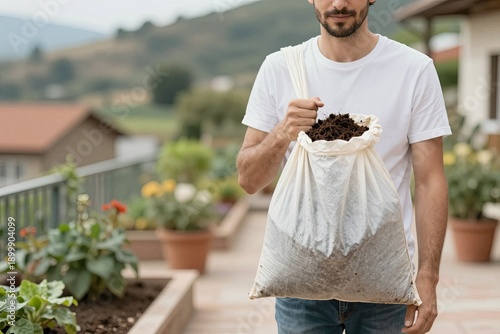 A man with a bag of soil in the garden