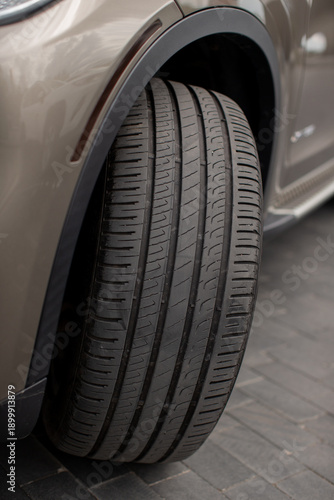 Car tire with visible tread on paved road