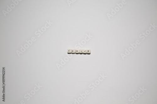 Fotografía Top-down minimalist image of the word choice using letter blocks on a white background, representing decision making and options