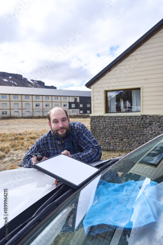 Man positioning a satellite internet receiver antenna on the front of his car to get a signal and connect to the network while traveling. Technology allows to stay connected from remote locations.