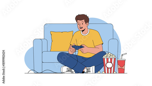 Happy young man sitting on the floor, playing video games with a controller, surrounded by popcorn and a soft drink, enjoying leisure time.