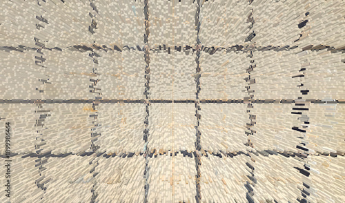 Top-down aerial view showing a grid-like pattern of dark lines drawn on a light-colored background, creating a series of squares across the white surface.