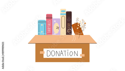 A cardboard donation box filled with books and a bouquet of flowers