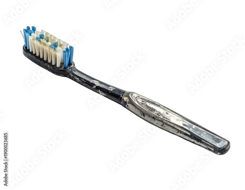 A worn and dirty black toothbrush with blue and white bristles against a stark black background.