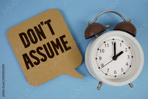 Don't Assume text with alarm clock on blue background