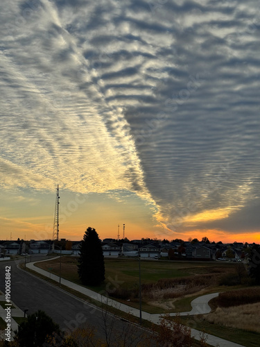 Dramatic cloud formation over suburban landscape at sunset