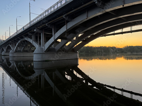 Fotografi Kyivskyi Bridge over Southern Bug River at sunset