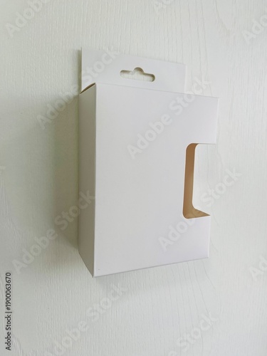 Side view of retail display box with hook and cut out side. minimal white retail packaging with a hang tab and die-cut window
