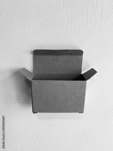 open gray cardboard box / mailer box on a white textured background