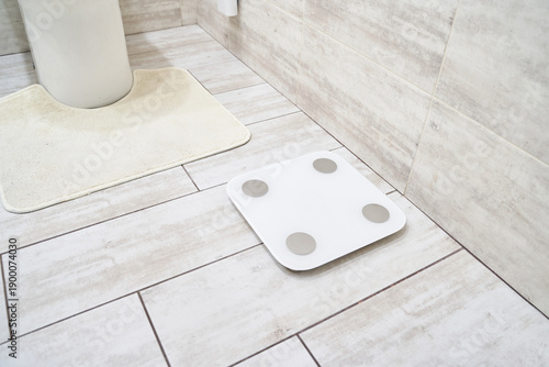 Tableau sur toile Digital bathroom scale on tiled floor in modern bathroom for accurate weight monitoring and health tracking