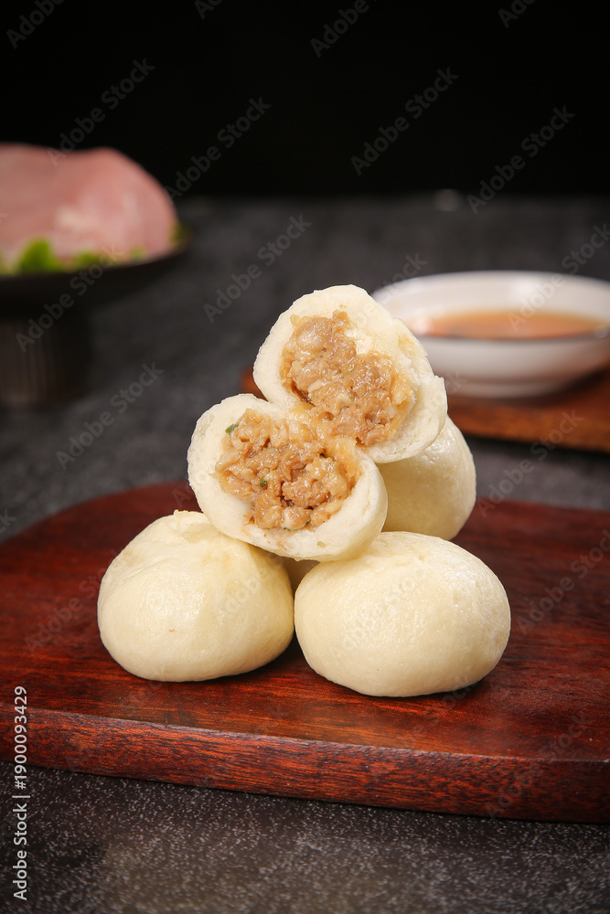 Fototapeta premium Traditional Chinese Steamed Dumplings with Meat Filling on Wooden Serving Board