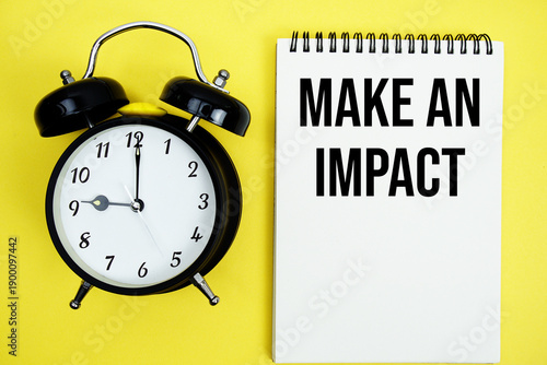 Make An Impact text with alarm clock flat lay on yellow background