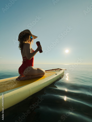 Young woman walking on stand up paddle sup boards by the sea during summer vacation