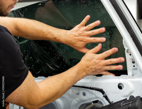 Positioning the tinting film on a car window during the application process