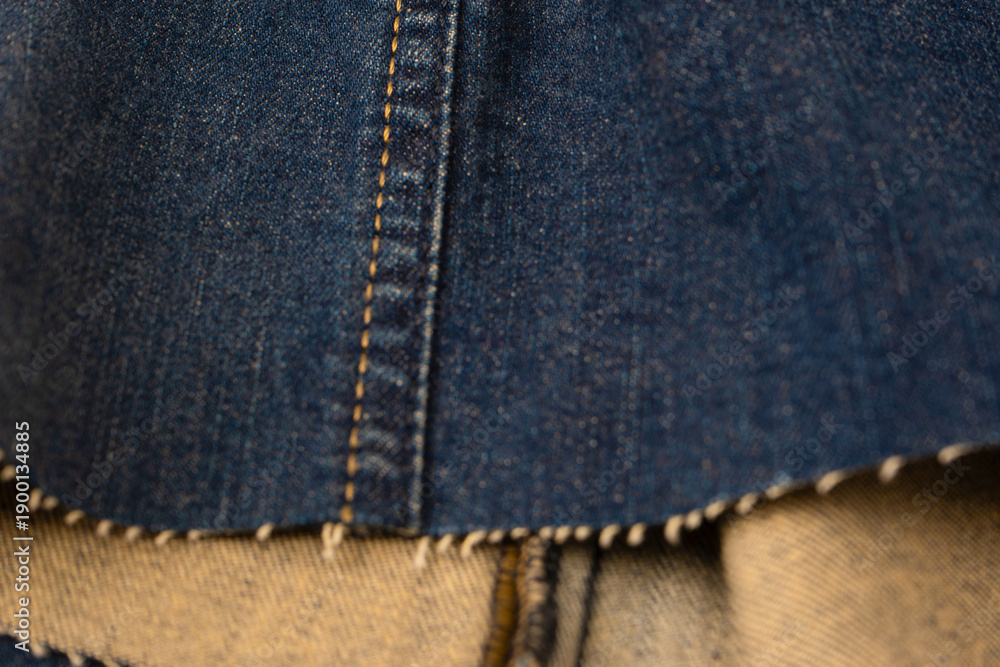 Fototapeta premium Blue denim fabric as a background. Top view.