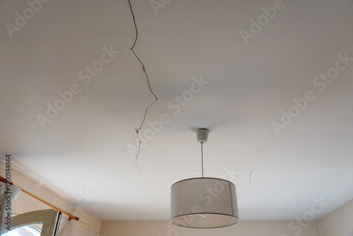 A crack is visible on the ceiling above a lamp