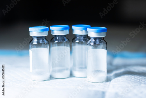 Vaccine vial inspection. Freezedried vaccine bottles displayed for safety assessment