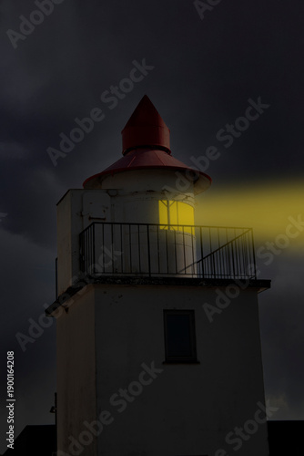 Close up of  an illuminated Lighthouse in a foggy night concept