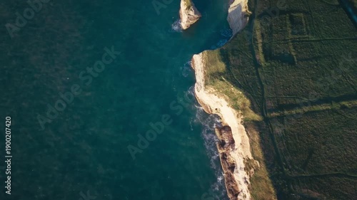 Drone footage of a chalky cliff coastline at sunrise