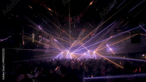 Crowd with Hands Up Recording on Smartphones Under Blue Green and Purple Laser Lights
