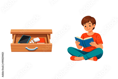 Boy sits on floor and reads book while drawer is open with phone and other items inside during daytime at home